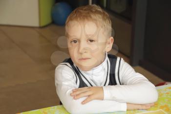 Portrait of sitting boy in white cloth