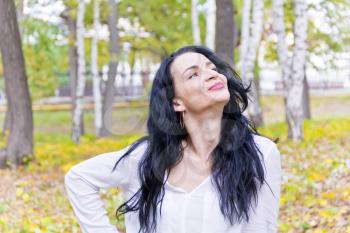 European woman with black hair in autumn park
