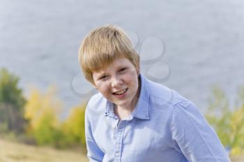 Portrait of cute blond boy in autumn park