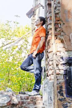 Man standing near old brick wall in summer orange color