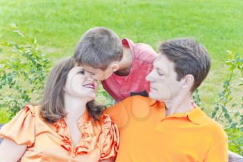 Happy family son kissing pregnant mother in summer time
