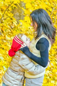 Photo of smiling mother and daughter in autumn