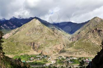 Picturesque landscape with a small village at the foot of mountains