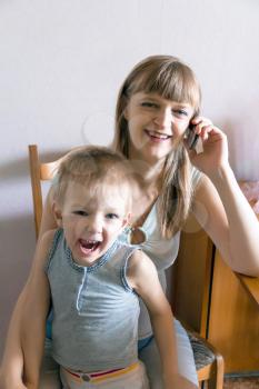 Pregnant woman talking by mobile with angry son