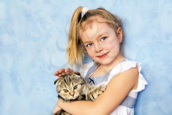 Blond girl with grey kitty on blue