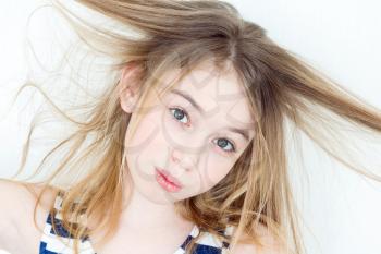 Portrait of girl eleven years old with big eyes playing with long hair