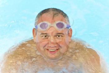 Portrait of big fat smiling man in swimming pool water