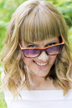 Vertical portrait of laughing woman with blond hair in sunglass
