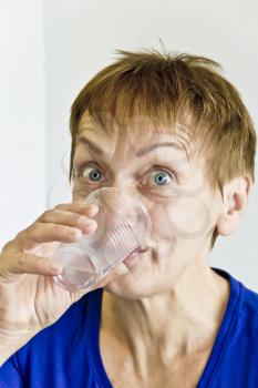 Elderly woman with short haircut are drinking a water