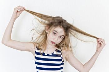 Cute girl eleven years old playing with blond long hair on white background