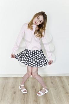 Cute girl eleven years old with blond long hair on white background