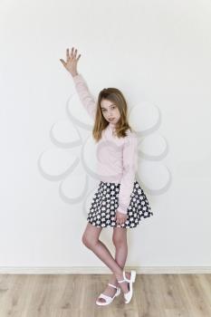 Girl eleven years old with blond long hair on white background