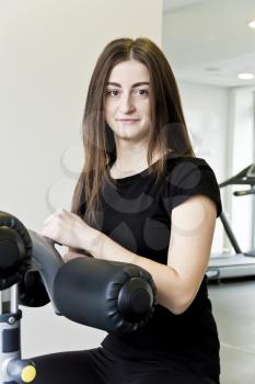 Vertical photo of brunette with long hair to train in gym