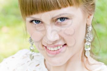 Portrait of blue eyes and blond hair bride on green background