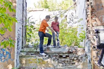 Father and teenager son are playing in ruins