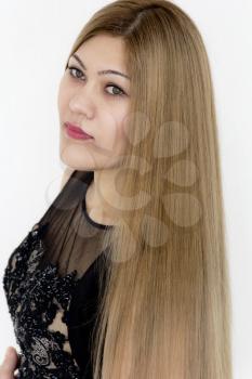 Attractive young girl with brown healthy straight hair in evening black dress