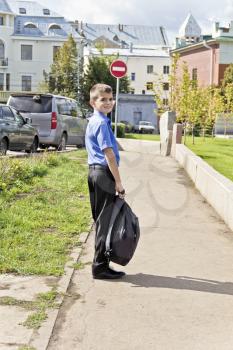 Brunette boy are walking with school backpack