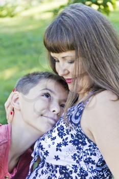 Vertical portrait of loving mother hugs with teenager son