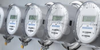 Digital electric meters in a row measuring power use. Electricity consumption concept. 3d illustration