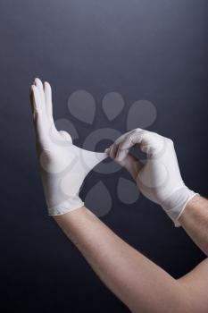Male hands in latex gloves on dark background