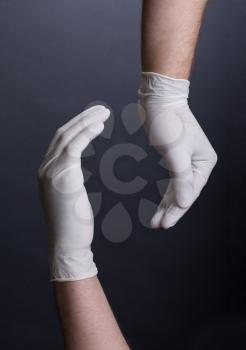 Male hands in latex gloves encircling, on dark background. Place for a concept.