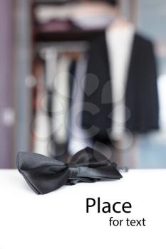 Bow tie with open closet and tuxedo. Getting ready for formal night. With isolated place for text.
