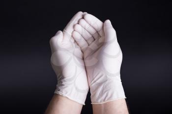 Male hands in latex gloves on dark background
