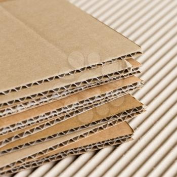 Cardboard pile on corrugated cardboard texture. Industrial background.