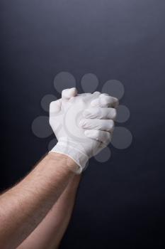 Male hands in golves. Clasped hands. Doctor or nurse wearing latex gloves. . Dark background