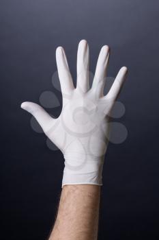 Male palm in latex glove. Doctor or nurse hand in sanitary glove. Dark background