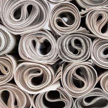Stack of newspapers rolls, paper texture background.