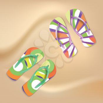 Colored beach slippers with pattern on the sandy background