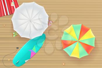 Background for summer holidays. Colored sun umbrellas, surfboard, flip-flops and a beach Mat on the wooden background from light brown straps. Tropical seashore, top view. Summer travel background.