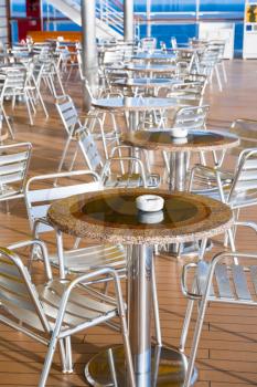 tables with ashtrays in outdoor bar on stern of cruise liner