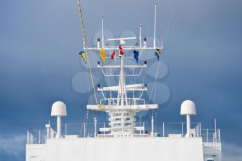 flags of european countries on navigation antenna of cruise liner