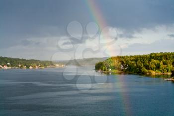 rainbow in rain during sunshine in Baltic sea