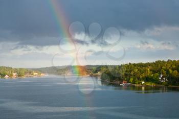 rainbow in rain during sunshine in Baltic sea