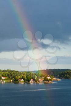 rainbow under small village on Baltic seashore