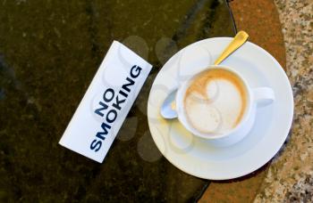cup of cappuccino  on no-smoking table in outdoor cafe