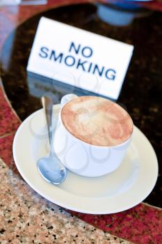 cup of cappuccino  on no-smoking table in outdoor cafe