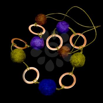 bead from felt balls and brass rings isolated on black 