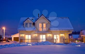 country house with evening electric light in winter
