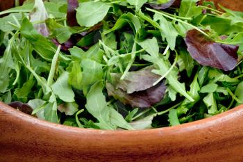 fresh salad mix in wooden bowl closeup