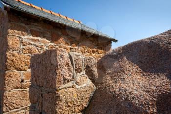 wall of traditional stone Breton house made from granite rock