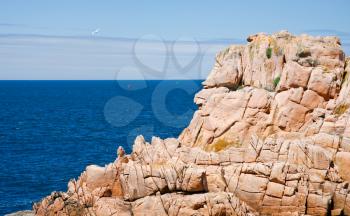 view on sea through pink cliff of Ile de Brehat, Brittany, France