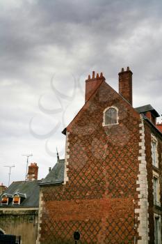 brick wall of old  house with grey clouds background
