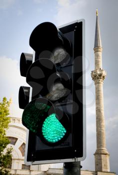 green traffic light with minaret in background in Istanbul