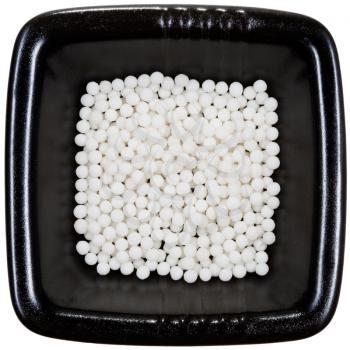 sugar homeopathy balls on black plate close up