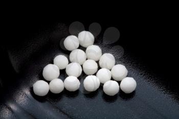 sugar homeopathy balls in black container close up