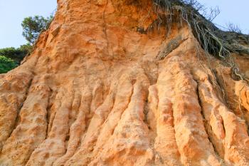 slope of orange sand hill in Algarve, Portugal